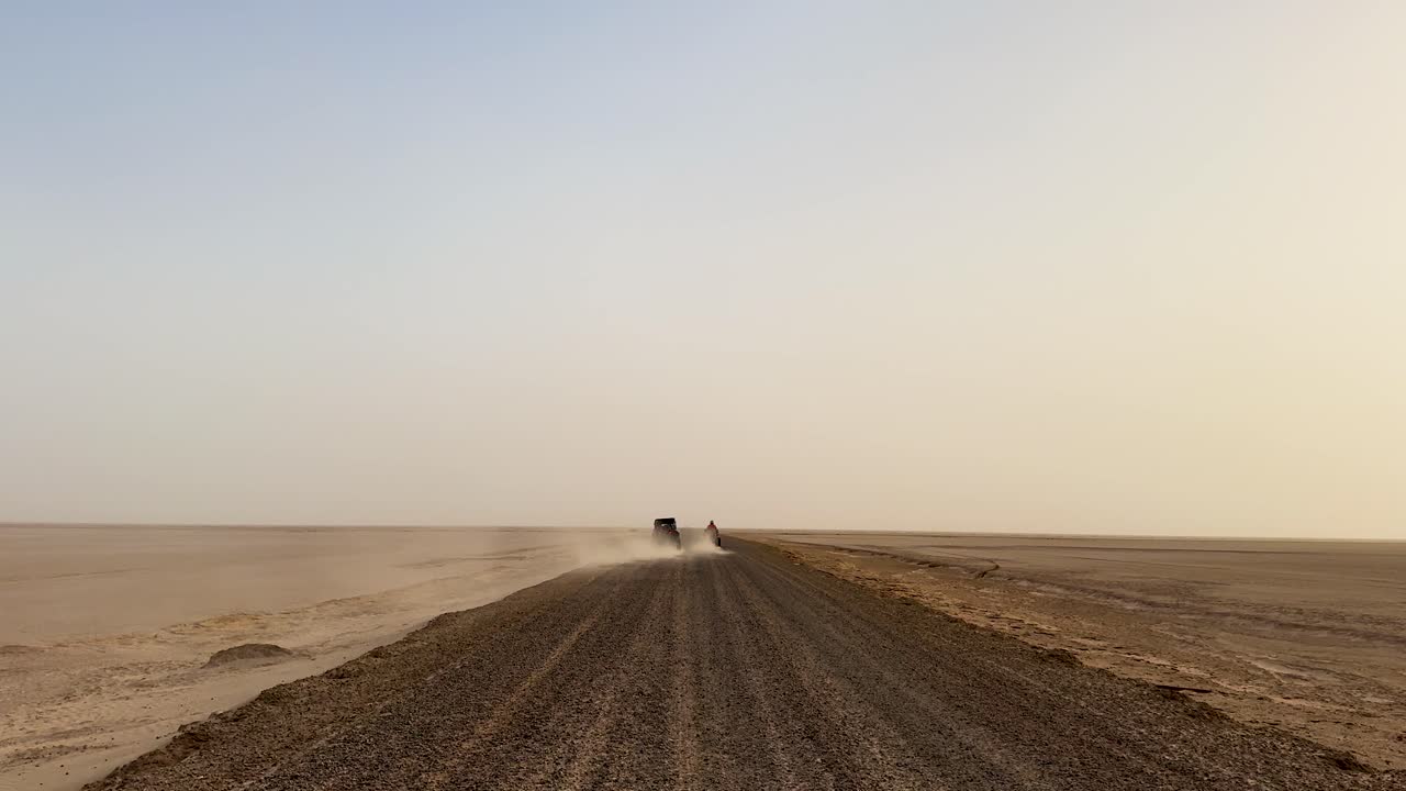 Buggy and motorbike ride across sandy road at sunset with dust clouds symbolizing endurance speed freedom adventure exploration resilience and the raw challenge of motorsport in vast wilderness