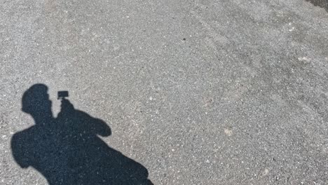 shadow of a person recording with a smartphone.