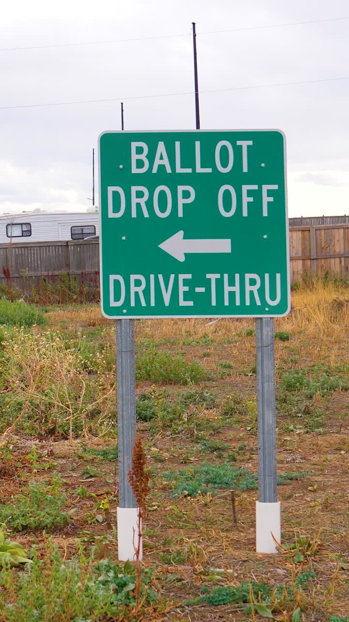 A roadside ballot drop-off arrow sign directs voters toward the ballot box, representing democracy, safety, responsibility, civic engagement, equal access, importance of participation. Vertical Video