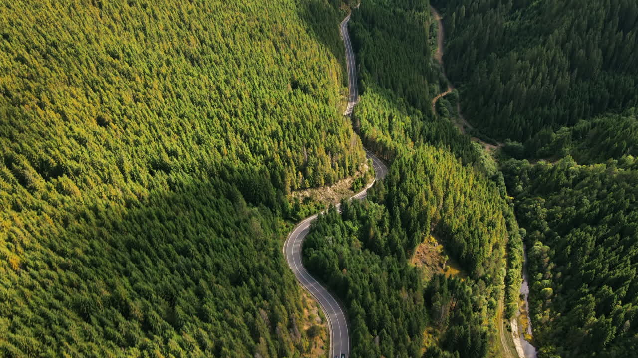 Aerial drone view of nature in Romania. Carpathian mountains, hills lush greenery, valley with Transalpina road
