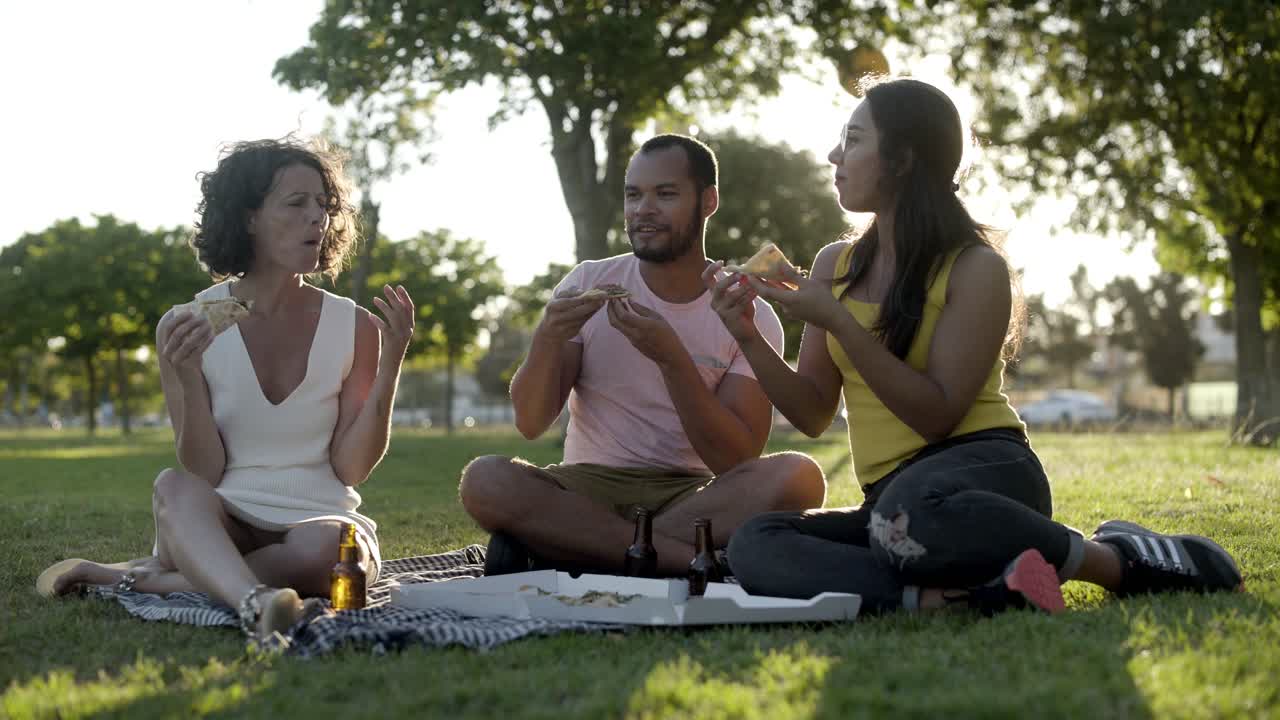 amigos jóvenes comiendo pizza al aire libre