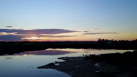 Imágenes-Aéreas-De-Puesta-De-Sol-Con-Drones-Sobre-Aguas-Tranquilas-A-Baja-Altura-Hacia-El-Sol