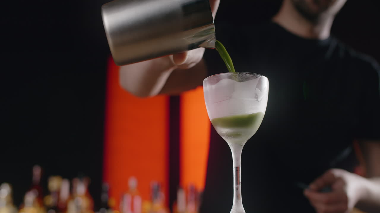 Bartender laver en grøn cocktail