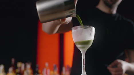 bartender making a green cocktail