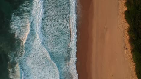 waves breaking onto a sandy beach