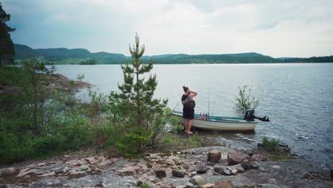 tranquil scenic of a barefoot man picking up bags on a boat to go to an island camping in trondelag, norway