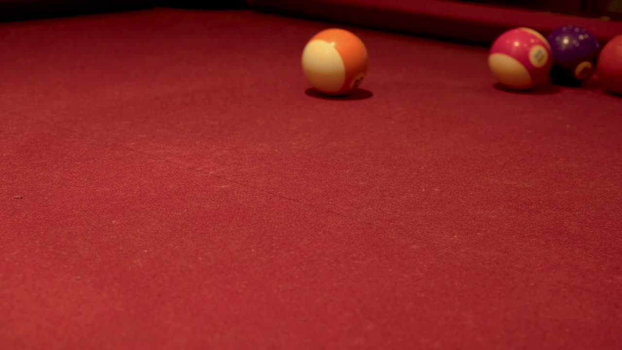 Bola blanca golpeando muchas bolas de billar sobre una alfombra roja
