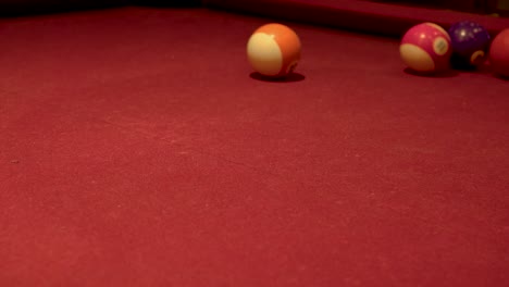 Cue-ball-hitting-many-pool-balls-on-a-red-carpet