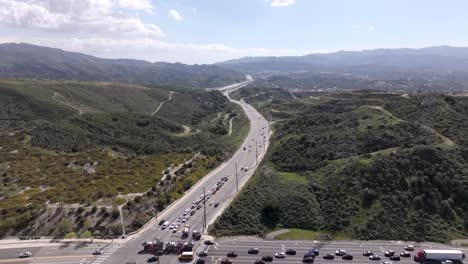 Luftaufnahme-Von-Autos-Und-Lastwagen,-Die-Während-Der-Hauptverkehrszeit-In-Los-Angeles-Durch-Eine-Kreuzung-Fahren