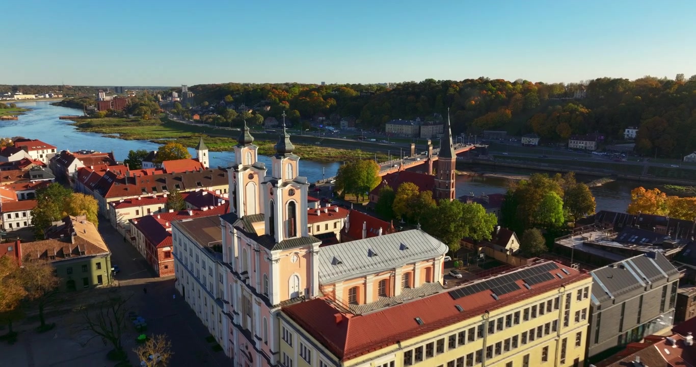 Kaunista ilmakuvaa Kaunasin vanhastakaupungista, Liettuasta, Euroopasta. Pitkä lento vihreän stadionin, kaupungintalon, Vytautasin kirkon kautta Aleksotasin sillalle. Kirkas syysilta. 4K-kuvamateriaali