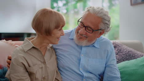 Senior-couple-looking-at-each-other.-Mature-woman-and-man-sitting-on-sofa