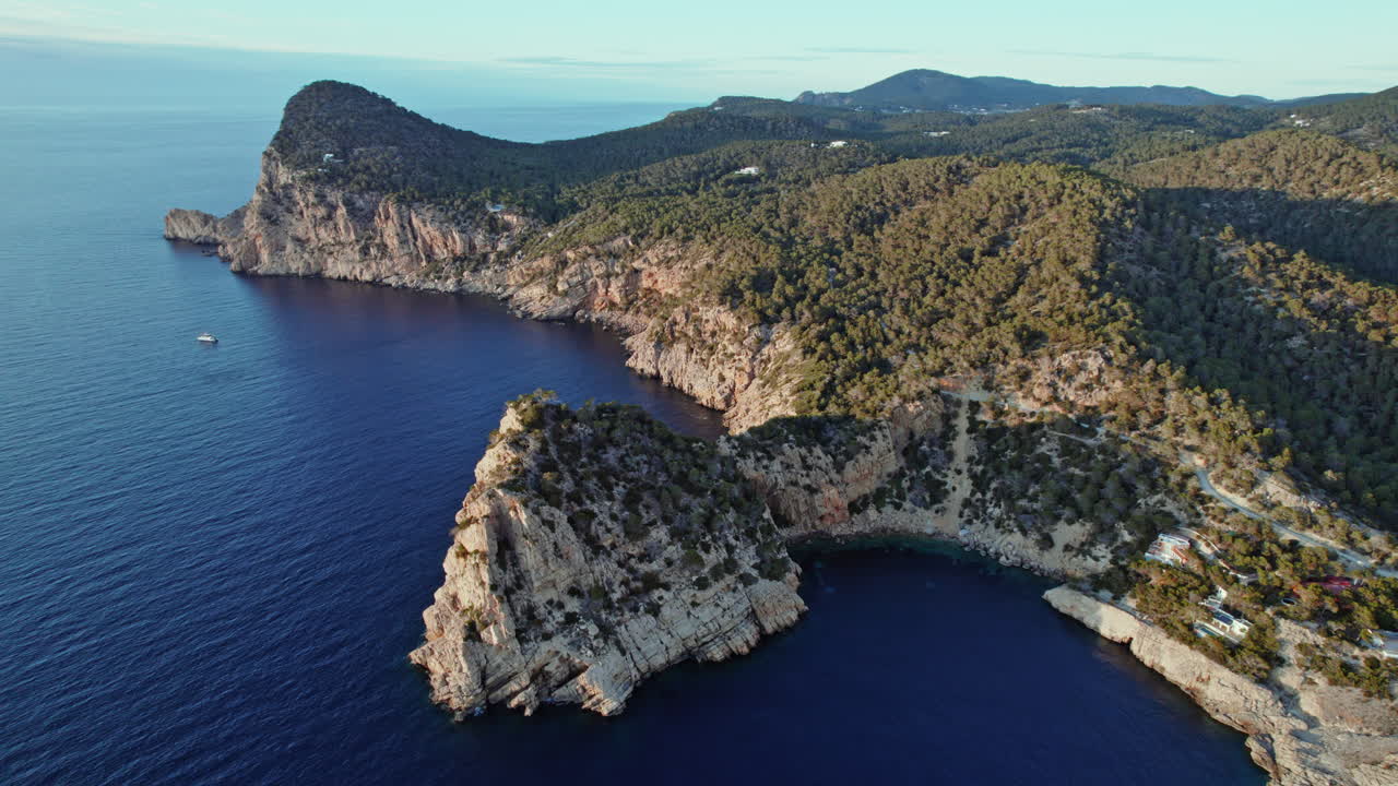 Scenic Rocky Cliffs Enclosed By Blue Ocean Water At Cala Salada In Ibiza, Spain, aerial, wide shot