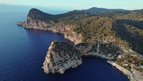 Pintorescos-Acantilados-Rocosos-Rodeados-Por-Agua-Azul-Del-Océano-En-Cala-Salada-En-Ibiza,-España,-Aéreo,-Plano-Amplio