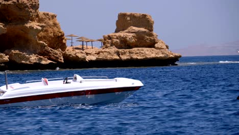barco a motor anclado en el mar contra el paisaje de playa rocosa y la costa en egipto