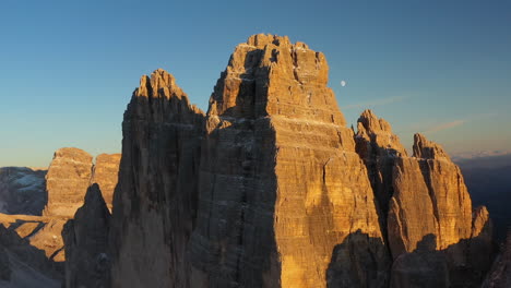 Rotating-cinematic-drone-shot-of-Tre-Cime-di-Lavaredo-in-Italy,-showing-the-peaks-Cima-Piccola,-Cima-Grande-and-Cima-Ovest