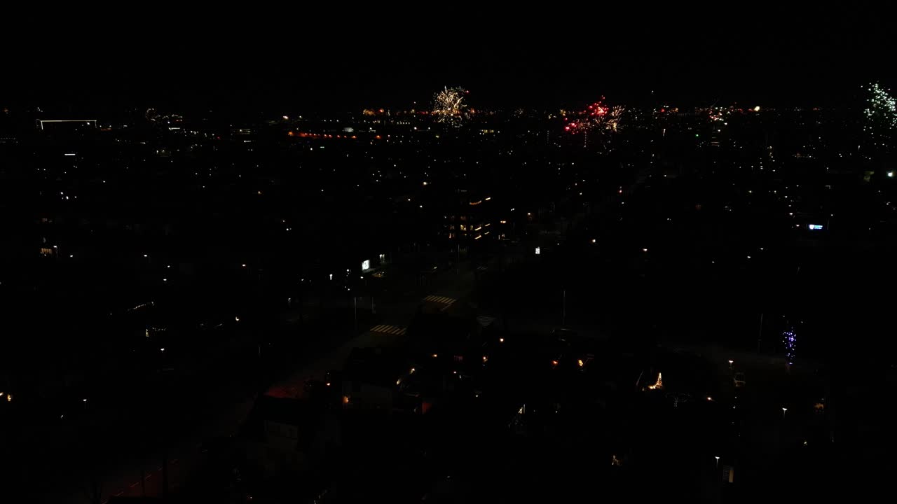 vista aérea de los fuegos artificiales que se disparan en las calles urbanas por la noche.