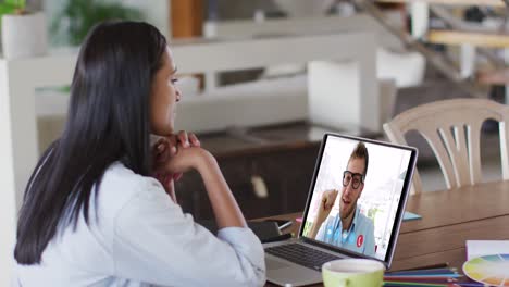 caucasian woman using laptop on video call with male colleague working from home