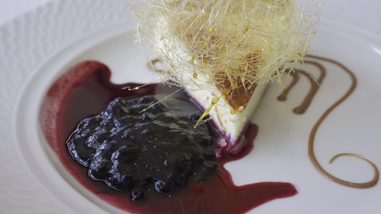 Close up of a piece of cheesecake with blueberry sauce on a white plate