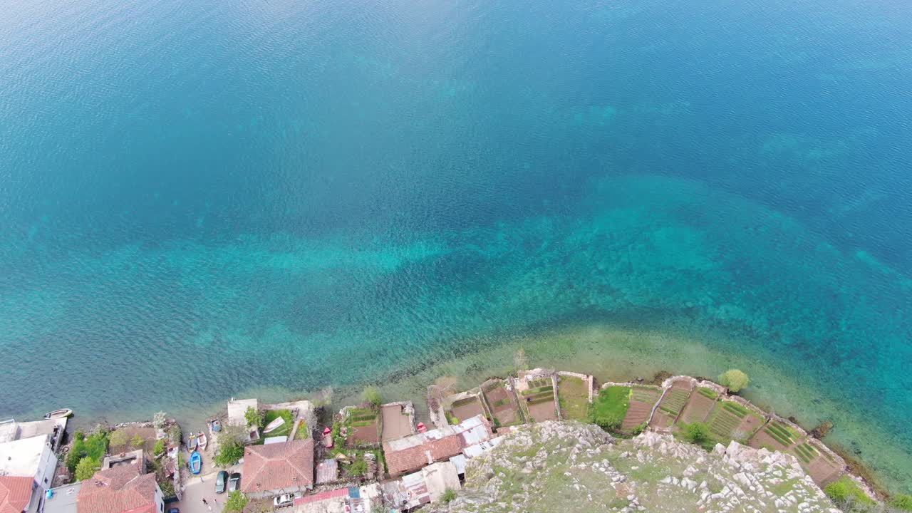 vista del dron en albania volando sobre una montaña verde con una pequeña ciudad a ohrid lago vista superior agua cristalina