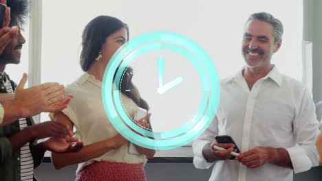 animation of clock over happy diverse male and female business colleagues clapping hands in office