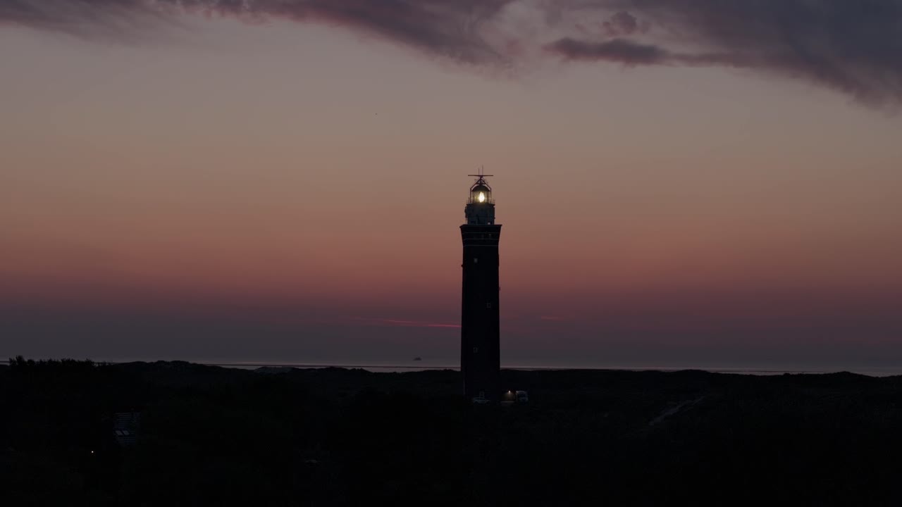 Veduta aerea di un tramonto mozzafiato al faro di Westhoofd con luce calda sulle dune e sul Mare del Nord a Ouddorp