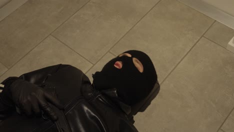 a burglar or nagster is lying on the ground and has been injured. he cannot get up.