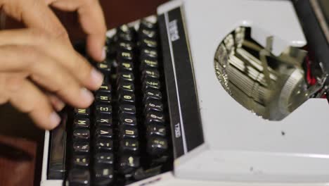 vista de perfil del mecanógrafo probando una máquina de escribir antigua con barras de tipo en movimiento
