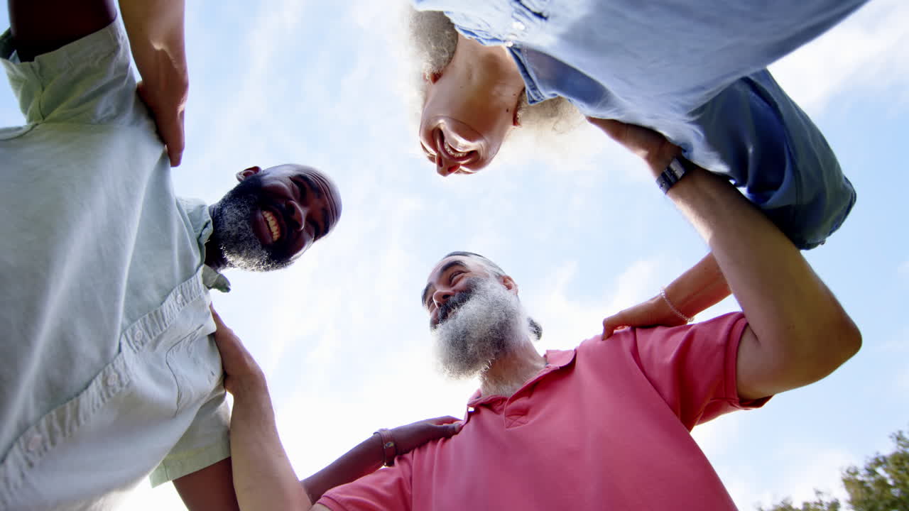 Embracing and laughing together outdoors, senior friends enjoying companionship