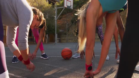 equipo de baloncesto femenino diverso con ropa deportiva, estiramiento