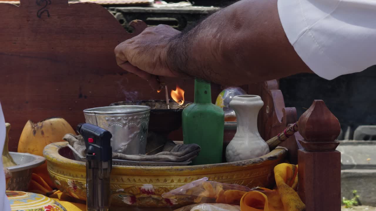 En balinesisk hindupräst utför en bön med närbild av traditionella offergåvor. Fångar helig ritual, andlig atmosfär och rikt kulturarv i ett autentiskt religiöst ögonblick.
