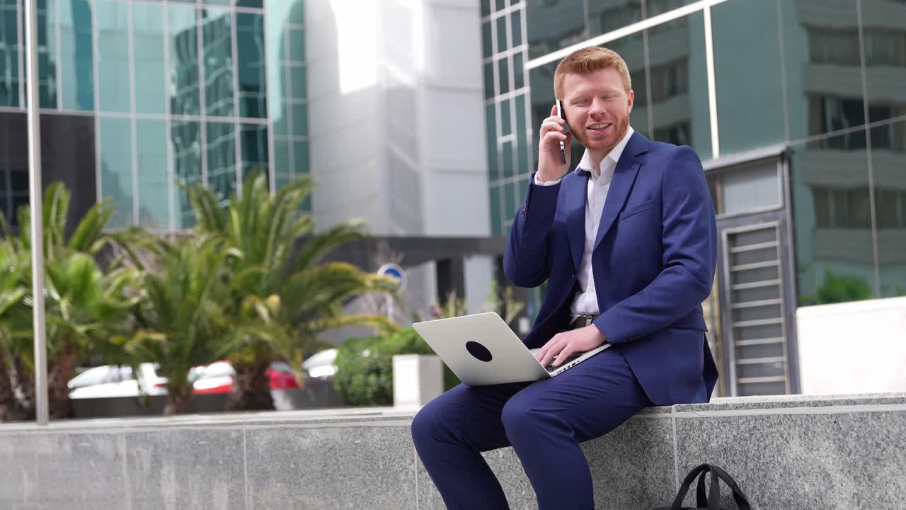 Forretningsmand, der arbejder med bærbar computer og telefon udendørs