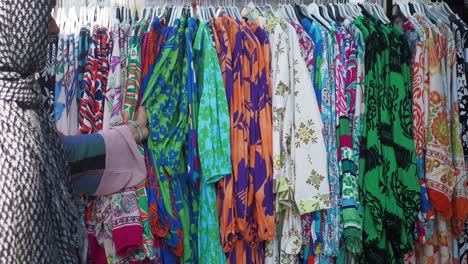 woman shopping for colorful printed dresses at a clothing store