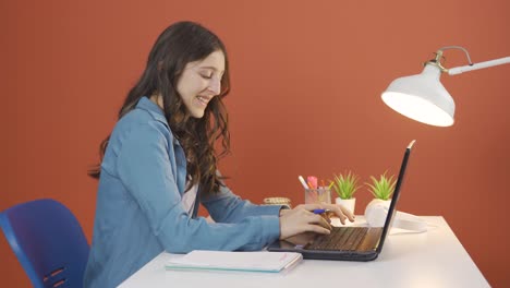 Young-woman-working-on-laptop-with-happy-expression.