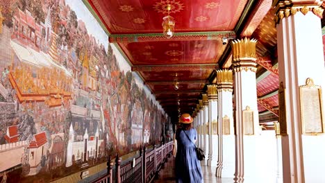 visitor admires intricate murals in bangkok temple