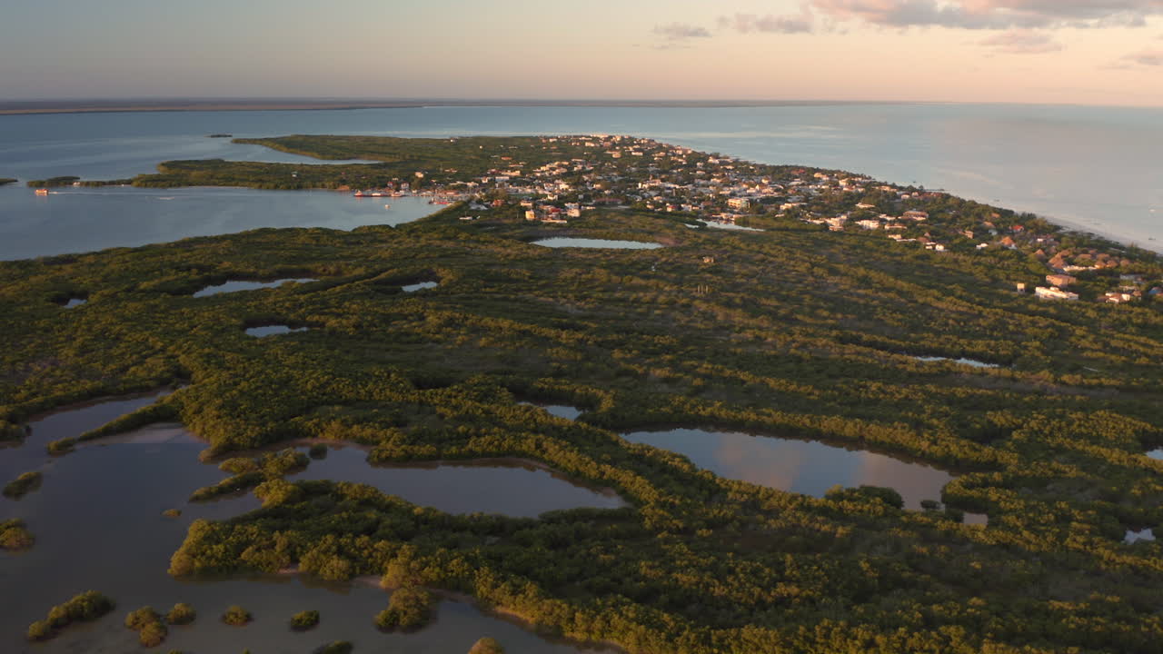 península marítima con lagos, selva tropical y pequeña ciudad bajo el cielo al anochecer