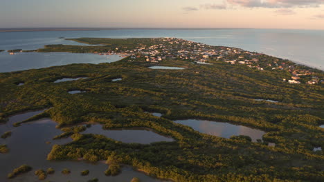 sea peninsula with lakes, rainforest and small town below dusking sky