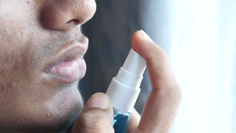 person using mouth spray