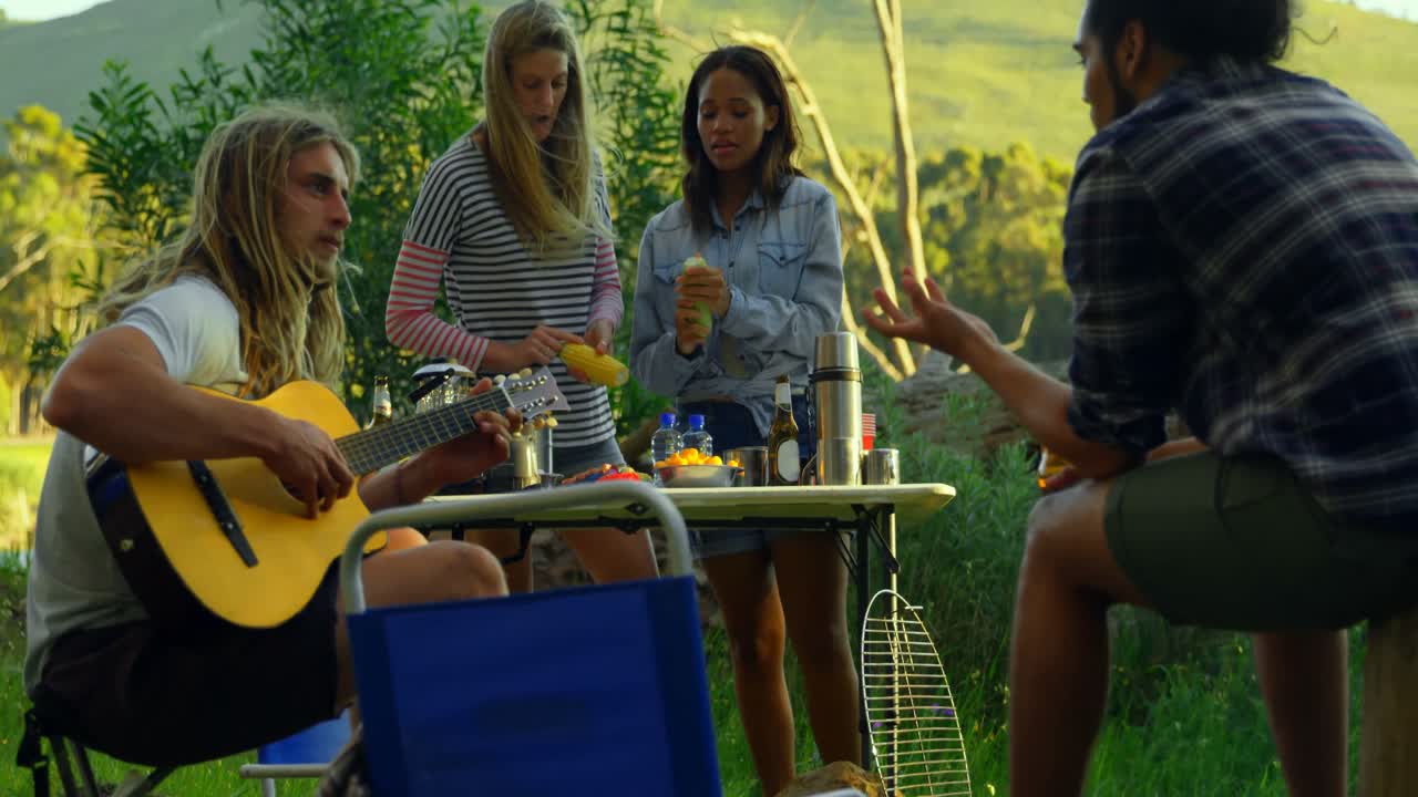 친구 들 이 숲 에 있는 불 근처 에서 즐기고 있다 4k