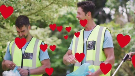 animation of red hearts over celebrating caucasian group picking up rubbish in countryside