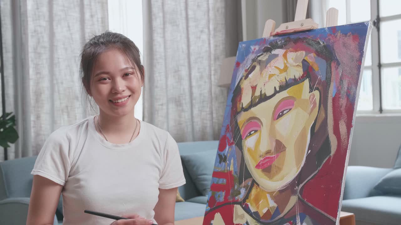 Asian Artist Girl Sitting And Holding Paintbrush Mixed Colour And Smiling After Finish Painting A Girl On The Canvas