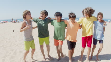 boys hugging each others neck and jumping for joy on beach