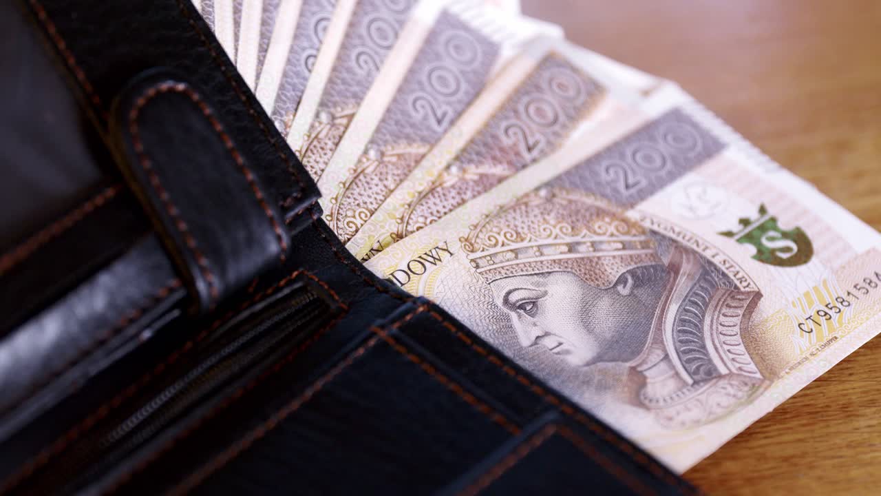 Polish money put into the wallet, cash sticking out of the wallet, Zloty, PLN