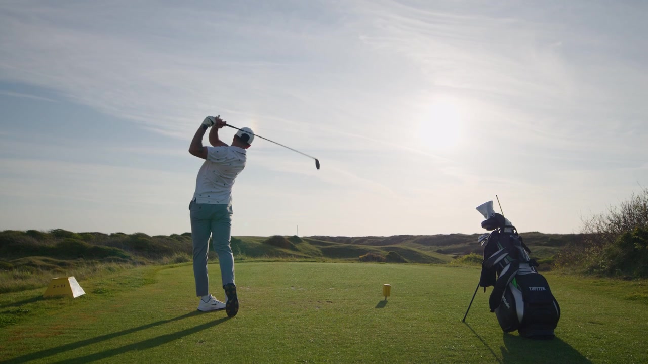 Crane shot of Golfer swing and hitting ball of tee, driver shot slomo