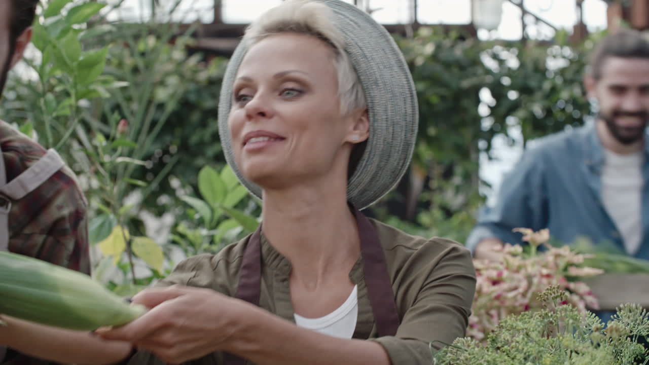 카메라는 고객에게 서비스를 제공하는 동안 식료품 가게의 금발 여성 점원에게 초점을 맞춥니다.