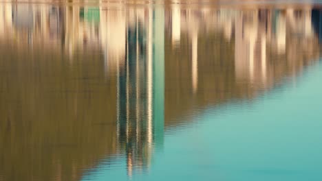 a reflection in the lake water of the lafarge exshaw limestone cement plant industrial building off trans-canada highway one in the canadian rocky mountains