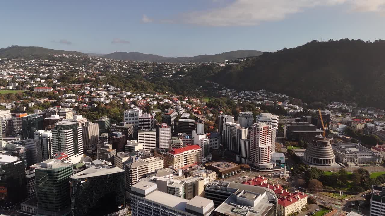 Central business district of Wellington, capital city, Beehive parliament building, dense urban landscape of New Zealand, residential suburbs. Aerial panning