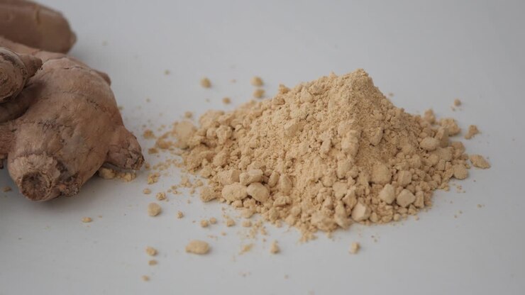 Ginger Powder and Fresh Ginger Roots on White Background