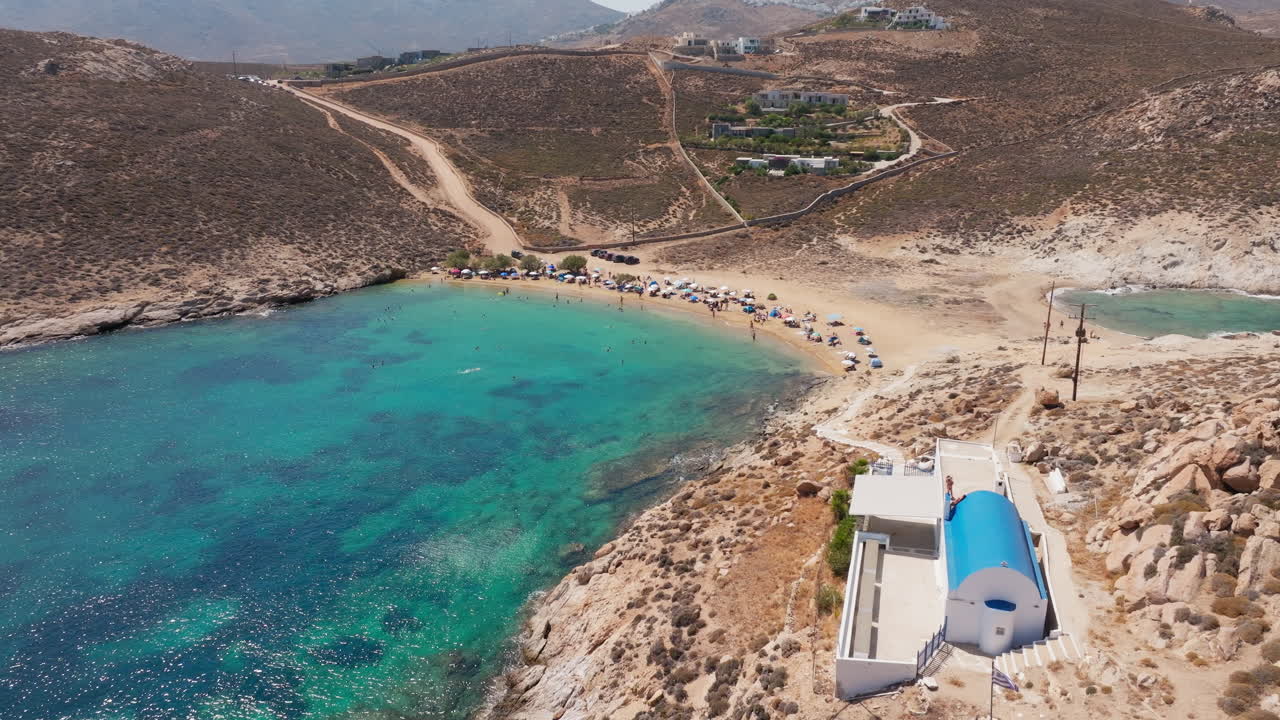 Agios Sostis Beach with turquoise waters and white chapel beside shore on Serifos island