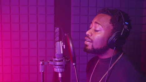 man singing into microphone in recording studio