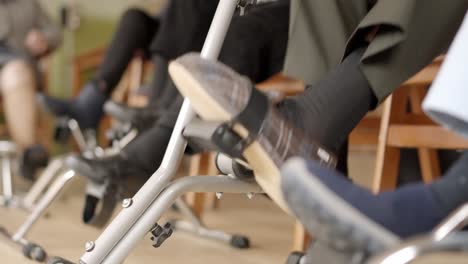legs of senior people pedaling sitting on a nursing home